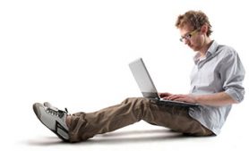 person sitting on ground with a laptop