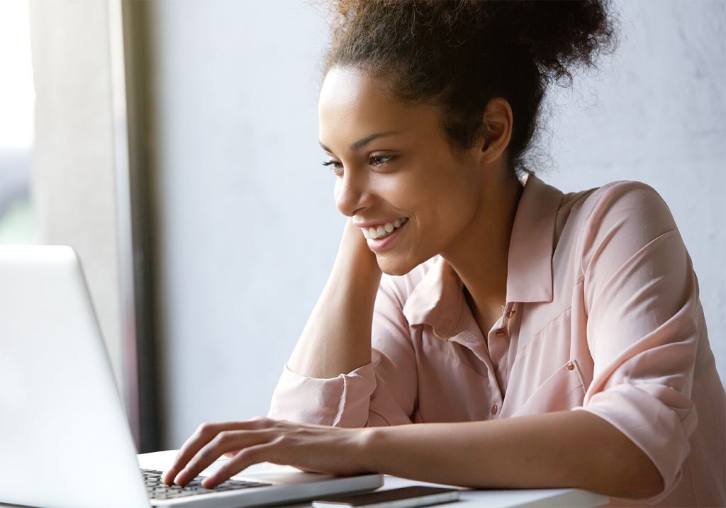 women sitting at desk on a labtop